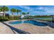 Community pool and lounge area surrounded by palm trees with lakeside views at 2945 Simile St, Kissimmee, FL 34746