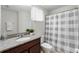 Cozy bathroom features granite sink countertop, and a shower with a gray and white patterned curtain at 3270 Mt Vernon Way, Kissimmee, FL 34741