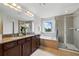 Bright bathroom featuring a double vanity, soaking tub, glass-enclosed shower, and a view to the outside at 3270 Mt Vernon Way, Kissimmee, FL 34741