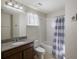 Bathroom featuring a single vanity, mirror, and shower-tub combination with patterned curtain at 3270 Mt Vernon Way, Kissimmee, FL 34741