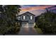 Twilight view of a two-story home featuring a two-car garage, well-lit for an inviting atmosphere at 3270 Mt Vernon Way, Kissimmee, FL 34741