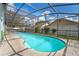 Enclosed pool with blue water, surrounded by trees at 3275 Windy Wood Dr, Orlando, FL 32812