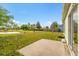 Landscaped backyard with a concrete patio and partial views of a pond at 3304 Kelsey Ln, St Cloud, FL 34772