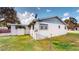 Exterior view of a home with a well-maintained lawn, fenced yard, and mature trees at 3520 Arch St, Orlando, FL 32808