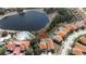 Aerial view of a home with a screened pool next to a lake and community pool at 390 Miro Dr, Davenport, FL 33837