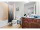 Bathroom with a combined bathtub and shower, wooden vanity, and a white toilet, offering essential amenities at 390 Miro Dr, Davenport, FL 33837