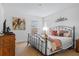 Comfortable bedroom featuring a metal frame bed with a cozy quilt and neutral-toned walls and carpet at 390 Miro Dr, Davenport, FL 33837