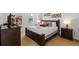 Well-lit bedroom featuring a dark wood bed frame, two windows, and neutral carpet and walls at 390 Miro Dr, Davenport, FL 33837