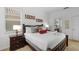 Well-lit bedroom featuring a dark wood bed frame, two windows, and neutral carpet and walls at 390 Miro Dr, Davenport, FL 33837