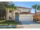 Two-story house featuring a terra cotta tile roof, a two-car garage, and a blue front door at 390 Miro Dr, Davenport, FL 33837