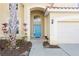 Close-up of the front entrance featuring a blue front door and arched entryway at 390 Miro Dr, Davenport, FL 33837