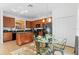 Bright kitchen featuring wooden cabinetry, black appliances, an island, and a glass table with seating for four at 390 Miro Dr, Davenport, FL 33837