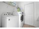 Bright laundry room with a washer, dryer, and storage shelves, providing convenience for laundry tasks at 390 Miro Dr, Davenport, FL 33837
