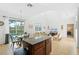 Open-concept living area with a kitchen island, sliding glass doors to the pool, and comfortable seating at 390 Miro Dr, Davenport, FL 33837