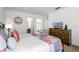 Comfortable main bedroom with a large bed, dresser, and view into the ensuite bathroom at 390 Miro Dr, Davenport, FL 33837