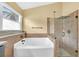 Bathroom featuring a separate shower with glass door and large soaking tub at 477 Bohannon Blvd, Orlando, FL 32824