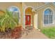 Close up of the elegant red front door with decorative glass and brick paver walkway at 477 Bohannon Blvd, Orlando, FL 32824