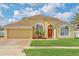 Inviting single-story home with a vibrant red front door, arched windows, and well-maintained landscaping at 477 Bohannon Blvd, Orlando, FL 32824