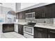 Gourmet kitchen boasts stainless steel appliances, dark wood cabinetry, and tile flooring throughout the space at 477 Bohannon Blvd, Orlando, FL 32824