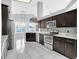 Modern kitchen features stainless steel appliances, dark wood cabinets and marble countertops at 477 Bohannon Blvd, Orlando, FL 32824