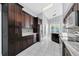 Spacious kitchen with dark wood cabinetry, tile flooring, stainless steel appliances, and modern lighting fixtures at 477 Bohannon Blvd, Orlando, FL 32824