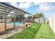 View of the enclosed pool with an open backyard and storage shed at 477 Bohannon Blvd, Orlando, FL 32824