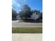 Exterior shot showcasing the garage and large shade tree, adding character to the property at 48 E Par St, Orlando, FL 32804