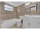 Bathroom features a tub, shower, toilet, vanity, mirror and tiled walls at 4804 Beacon St, Orlando, FL 32808
