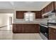 Functional kitchen with dark cabinets, stainless steel oven, light countertops, and tile backsplash at 4804 Beacon St, Orlando, FL 32808