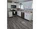 Updated kitchen featuring stainless steel appliances, granite countertops, and wood-look flooring at 50989 Highway 27 # 105, Davenport, FL 33897