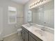 Bathroom with a dual sink vanity, a large mirror and modern lighting at 5323 Rochester Pl, St Cloud, FL 34771