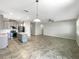 Open-concept living space with kitchen island, pendant lighting, and tile flooring at 5323 Rochester Pl, St Cloud, FL 34771