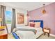 Cozy bedroom featuring a blue bed, lavender wall, and chic decor for a relaxing retreat at 537 Marcello Blvd, Kissimmee, FL 34746