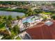 Aerial view of a community pool with cabanas surrounded by palm trees and a lake at 537 Marcello Blvd, Kissimmee, FL 34746