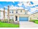 Beautiful two-story home showcasing a well-manicured lawn and a bright blue garage door at 537 Marcello Blvd, Kissimmee, FL 34746