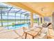 Screened-in patio with an outdoor dining table, a swimming pool, and peaceful lake views at 537 Marcello Blvd, Kissimmee, FL 34746