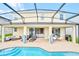 Back patio featuring a pool, lounge seating, and outdoor dining area with views of the home's bright interior at 537 Marcello Blvd, Kissimmee, FL 34746