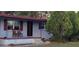 Quaint home featuring a welcoming front porch with chairs and a well-manicured lawn with established shrubbery at 5711 Riordan Way, Orlando, FL 32808