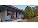 Charming home showcasing a cozy front porch with seating and lush, green landscaping in the front yard at 5711 Riordan Way, Orlando, FL 32808