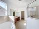 Bright bathroom with dual sinks, soaking tub, glass enclosed shower and walk-in closets at 603 Deauville Ct, Kissimmee, FL 34758