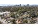 An aerial view of a suburban neighborhood with mature trees in the foreground and a cityscape in the background at 627 N Hyer Ave, Orlando, FL 32803