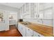 Kitchen with butcher block counters, white cabinets, and stainless dishwasher at 627 N Hyer Ave, Orlando, FL 32803