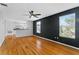 Living room featuring hardwood floors, ceiling fan, and a modern accent wall at 627 N Hyer Ave, Orlando, FL 32803