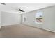 Spacious main bedroom boasts neutral walls, carpet, ceiling fan, and natural light from oversized windows at 627 N Hyer Ave, Orlando, FL 32803