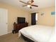 Neutral bedroom with a ceiling fan, dresser, and a view to the outside at 7119 Leighton Way, Orlando, FL 32822