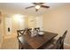 Bright dining room with a ceiling fan, dark wood table, and a shelf for displaying glassware at 7119 Leighton Way, Orlando, FL 32822