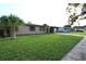 A well-kept single-story home with a lush green lawn and mature palm trees, exuding curb appeal at 7119 Leighton Way, Orlando, FL 32822