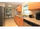 Well-lit kitchen with a double sink, wooden cabinets, and stainless steel dishwasher at 7119 Leighton Way, Orlando, FL 32822