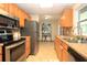 Compact kitchen featuring stainless steel appliances, updated countertops, and a view into an adjacent room at 7119 Leighton Way, Orlando, FL 32822