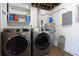 Laundry room with washer, dryer, hot water tank, and gray electrical panel at 7119 Leighton Way, Orlando, FL 32822